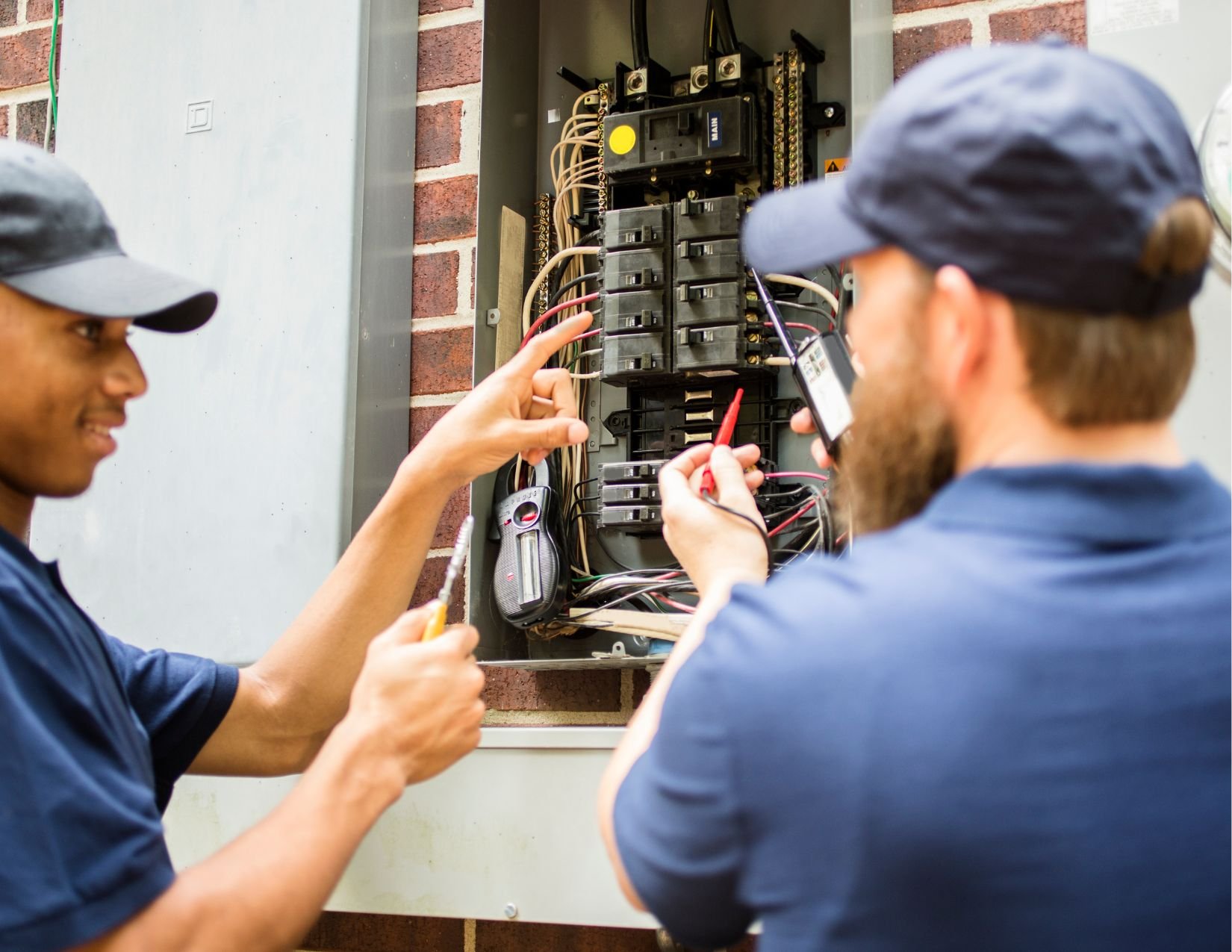 Electricians working on breaker box